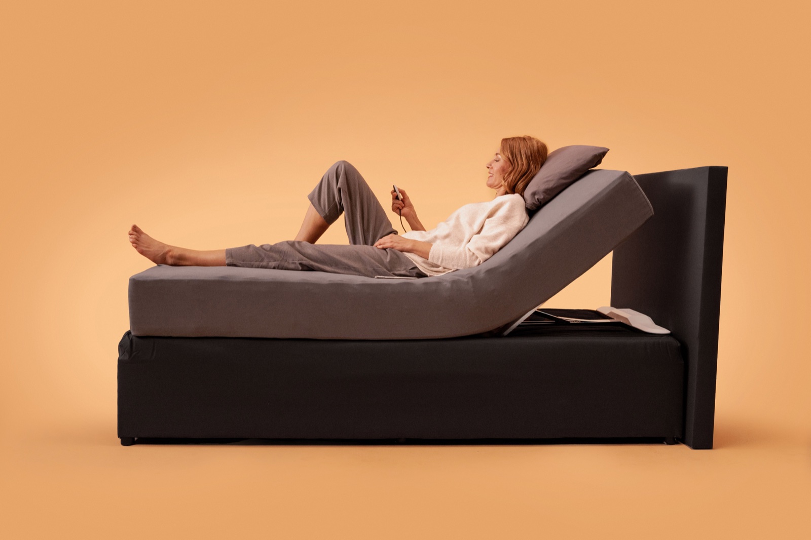 Mujer leyendo en la cama con el tronco elevado por el CosyLift